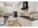 Kitchen featuring custom cabinetry, granite countertops, stainless steel appliances, and stone floors at 158 E Tampa Ave, Venice, FL 34285