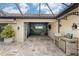 A beautiful tiled outdoor kitchen and mural wall decorate this covered patio space, ideal for entertaining at 158 E Tampa Ave, Venice, FL 34285