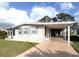 Single-story home featuring carport and sidewalk leading to a cozy screened-in patio at 16 Nautical Dr, North Port, FL 34287