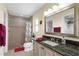 Bathroom with granite vanity top, large mirror, and a shower with decorative floral curtain at 1726 Claw Ct, Venice, FL 34293