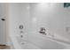 Bright bathroom featuring a white tiled bathtub, pristine fixtures, and minimalist decor at 1726 Claw Ct, Venice, FL 34293
