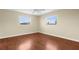 Bright bedroom featuring wood floors, ceiling fan, and two windows offering natural light at 1726 Claw Ct, Venice, FL 34293