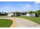 Single-story home with mature landscaping, a two-car garage, and a curved driveway at 1726 Claw Ct, Venice, FL 34293