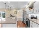 Modern kitchen featuring stainless steel appliances, white cabinets, stone countertops, and pendant lighting at 1726 Claw Ct, Venice, FL 34293