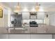 Close up view of the kitchen with a stone countertop, stainless steel appliances, and white cabinets at 1726 Claw Ct, Venice, FL 34293