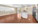 Bright kitchen with stainless appliances, hardwood floors, and bar seating that connects to the living area at 1726 Claw Ct, Venice, FL 34293