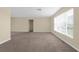 Spacious living room featuring neutral walls, plush carpeting, and natural light from a large window at 1726 Claw Ct, Venice, FL 34293
