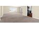 Bright living room featuring neutral carpet, light colored walls, and a doorway leading to the kitchen at 1726 Claw Ct, Venice, FL 34293