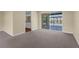 Bright living room with carpet floors and sliding doors to the lanai with pool views at 1726 Claw Ct, Venice, FL 34293