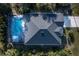 Aerial view of a home with a pool, showcasing the roof and surrounding trees at 177 Ingram Blvd, Rotonda West, FL 33947