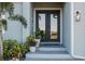 Elegant front entry with double glass doors framed by potted plants and modern lighting at 177 Ingram Blvd, Rotonda West, FL 33947