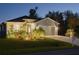Charming single-story home with well-lit landscaping, enhancing its curb appeal at dusk at 177 Ingram Blvd, Rotonda West, FL 33947