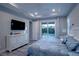 Main bedroom featuring tray ceiling, TV, and sliding glass doors leading to the pool at 177 Ingram Blvd, Rotonda West, FL 33947