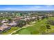 Picturesque aerial view of homes along a golf course with a lake, showcasing a beautiful community at 1995 White Feather Ln, Nokomis, FL 34275