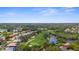 Expansive aerial view of a golf course community with homes surrounding the green, featuring a pond at 1995 White Feather Ln, Nokomis, FL 34275