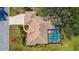 Aerial view of a home with a barrel tile roof, screened-in pool, and well-maintained landscaping at 1995 White Feather Ln, Nokomis, FL 34275