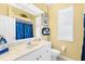 Bathroom with marble countertop, white cabinets and blue shower curtain at 1995 White Feather Ln, Nokomis, FL 34275