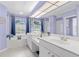 Bathroom features white countertops and cabinets, lavender walls and bathtub under a window at 1995 White Feather Ln, Nokomis, FL 34275