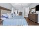 Comfortable bedroom with a view of hallway, tray ceilings, and wood flooring at 1995 White Feather Ln, Nokomis, FL 34275
