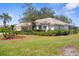 A home with lush landscaping, mature trees, and a barrel tile roof at 1995 White Feather Ln, Nokomis, FL 34275