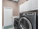 Laundry room has a laundry sink, full size washer and dryer, and overhead cabinets at 1995 White Feather Ln, Nokomis, FL 34275