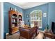 Office with custom wood desk, and built-in bookcase with view to window at 1995 White Feather Ln, Nokomis, FL 34275