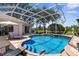 Beautiful pool with lush landscaping, privacy screen, and ample seating for relaxation and entertaining at 1995 White Feather Ln, Nokomis, FL 34275