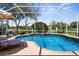 Beautiful in-ground pool with a screened enclosure and views of the lush landscaping and golf course beyond at 1995 White Feather Ln, Nokomis, FL 34275