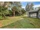 Backyard with a screened-in porch and a lot of trees at 2038 Mincey Ter, North Port, FL 34286