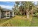Backyard with lush trees and a gray home at 2038 Mincey Ter, North Port, FL 34286