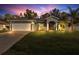 Charming single-story home with a manicured lawn and a two-car garage at twilight at 2038 Mincey Ter, North Port, FL 34286
