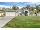 Well-maintained single-story home with a lush green lawn, two-car garage, and inviting curb appeal at 2038 Mincey Ter, North Port, FL 34286