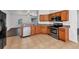 Well-lit kitchen features stainless steel appliances, wood cabinets, and flows into the dining area at 2038 Mincey Ter, North Port, FL 34286