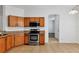 Clean kitchen boasts stainless steel oven, wood cabinets and an arched doorway leading to other rooms at 2038 Mincey Ter, North Port, FL 34286