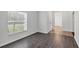 Living room with sleek wood flooring, a window with blinds and white walls at 2038 Mincey Ter, North Port, FL 34286