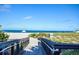 Beach access features walkway through lush landscaping with ocean views with beachgoers along the coastline at 20806 Valprato Ct, Venice, FL 34293