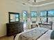 Bedroom featuring tray ceiling, access to pool, and seating area at 20806 Valprato Ct, Venice, FL 34293
