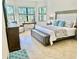 Bright primary bedroom with large windows, desk, and upholstered headboard at 20806 Valprato Ct, Venice, FL 34293