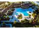 Aerial view of a community pool with lounge chairs, palm trees, and a clubhouse at 20806 Valprato Ct, Venice, FL 34293