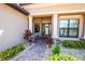 Charming front entrance with stone accents, manicured landscaping, and a decorative glass front door at 20806 Valprato Ct, Venice, FL 34293