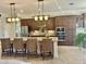 Spacious kitchen with a large island, granite countertops, stainless steel appliances, and stylish lighting at 20806 Valprato Ct, Venice, FL 34293