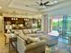 Open-concept living area with tile floors, a modern kitchen, and a comfortable sofa with access to the pool at 20806 Valprato Ct, Venice, FL 34293