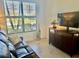 Comfortable living room featuring tiled floors, a large window and a dark wood media center at 20806 Valprato Ct, Venice, FL 34293