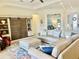 Bright living room with a neutral color palette and stylish built-in shelving with sliding wood doors at 20806 Valprato Ct, Venice, FL 34293