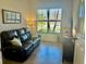 Comfortable living room featuring a large window with street views and a plush leather sofa at 20806 Valprato Ct, Venice, FL 34293