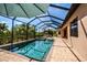 Stunning screened-in pool area offers a serene retreat with comfortable lounge seating and lush tropical landscaping at 20806 Valprato Ct, Venice, FL 34293