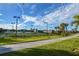 Outdoor tennis courts surrounded by green grass and landscaping on a sunny day at 20806 Valprato Ct, Venice, FL 34293