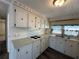 Bright kitchen with white appliances, light-colored countertop, and matching cabinetry at 217 Mantua Dr, Venice, FL 34285