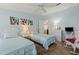 Light blue bedroom with two twin beds, white wicker furniture, and abstract art at 222 Como Dr, Venice, FL 34285