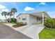 Inviting home featuring a covered carport, complemented by mature trees and lush landscaping at 222 Como Dr, Venice, FL 34285